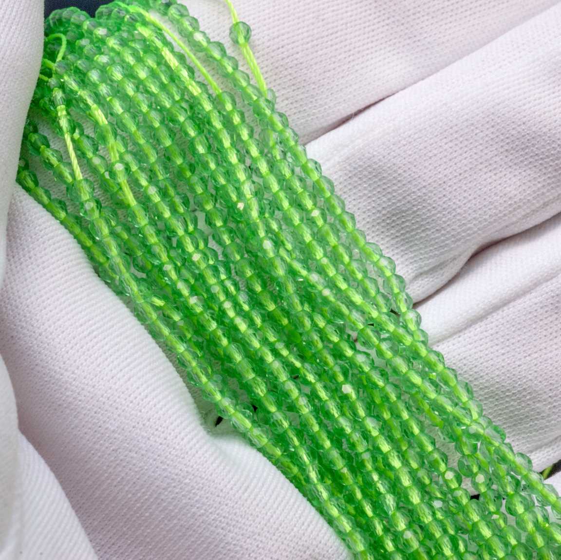 Нитка прозрачных хрустальных бусин на зеленой нити, цвет авантюрин (светло-зеленый), р-р 2х2мм, отв.0.8мм, ок. 36 см / 180 бусин.