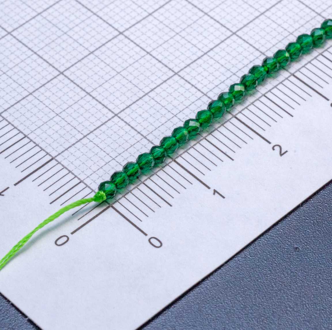Нитка прозрачных хрустальных бусин на ярко-зеленой нити, цвет изумруд (глубокий зеленый), р-р 2х2мм, отв.0.8мм, ок 36 см / 180 бусин.