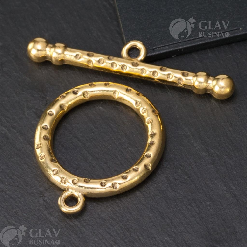 Привлекательное кольцо из бижутерного сплава в цвете античное золото. Размер кольца 26х21мм с замком-тоггл для удобного использования. Палочка длиной 37мм и отверстия диаметром 2мм добавляют особый шарм этому украшению.